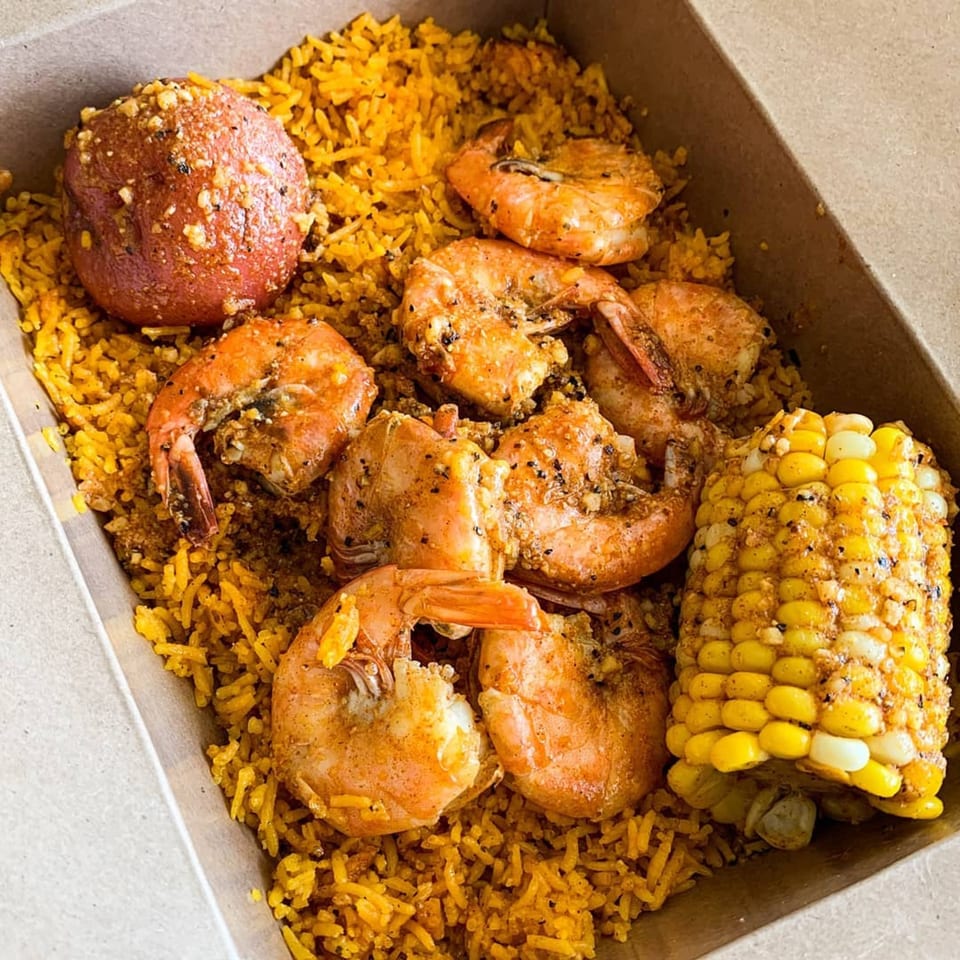 Bluff City Crab's seafood boil with shrimp, corn on the cob, and potato over seasoned rice.