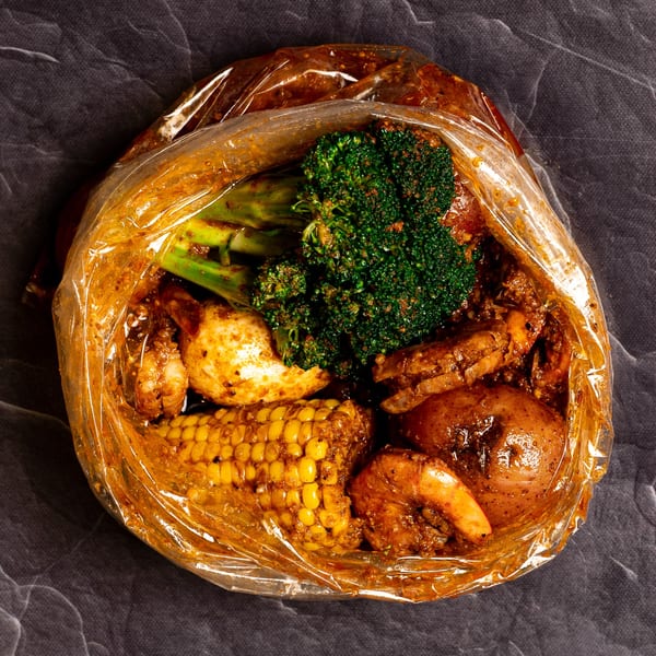 Bluff City Crab seafood boil bag with shrimp, crab, corn, potatoes, and broccoli.