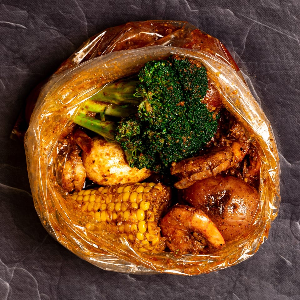 Bluff City Crab seafood boil bag with shrimp, crab, corn, potatoes, and broccoli.