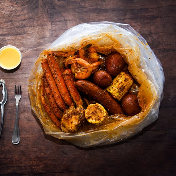 Bluff City Crab seafood boil bag with crab legs, shrimp, sausage, corn, and potatoes.